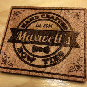 Maxwell's Bow Ties logo engraved on wood. 